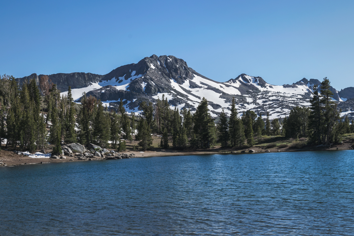 Alpine lake with mountains and patchy snow
