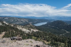 Cloud bank, blue skies, and forested mountains